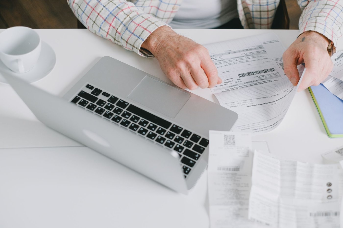 Funcionário de escritório digitando dados de papéis em um computador